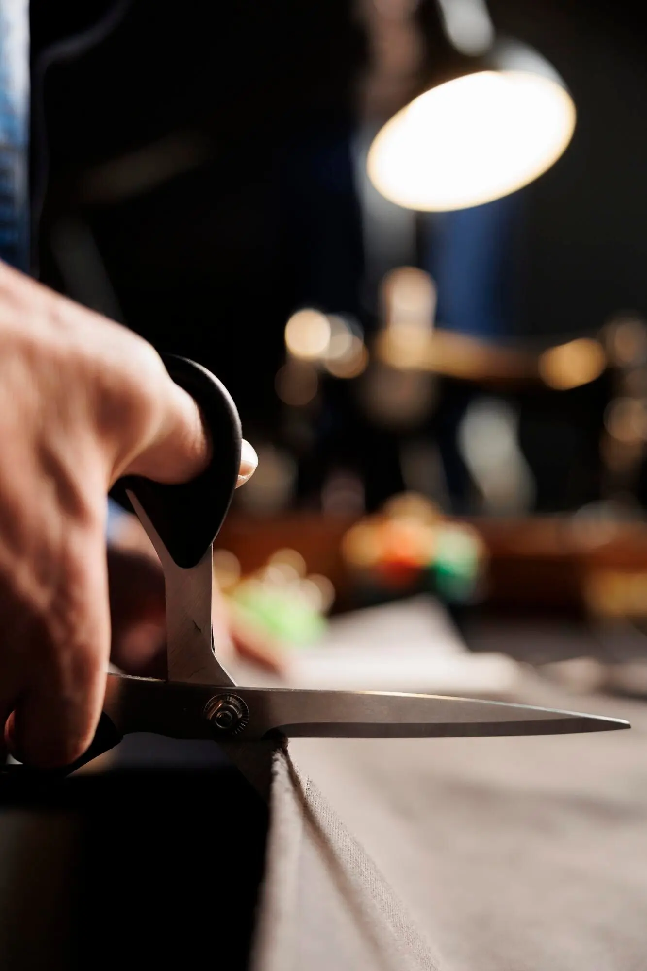 Ремесленник разрезает ткань ножницами.