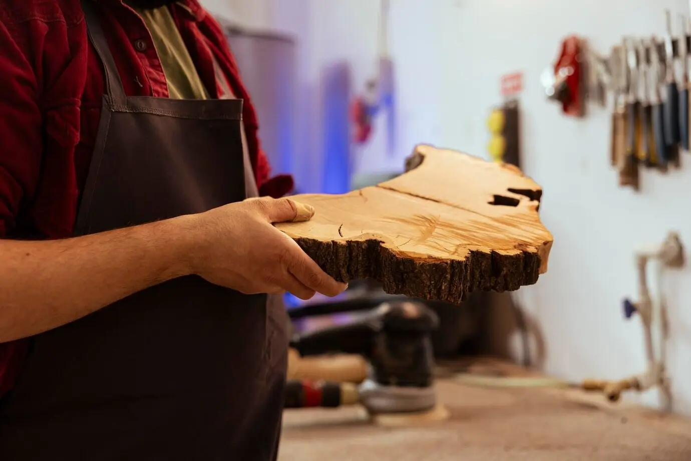 Крупным планом плотник осматривает деревянный брусок перед использованием для сборки мебели.